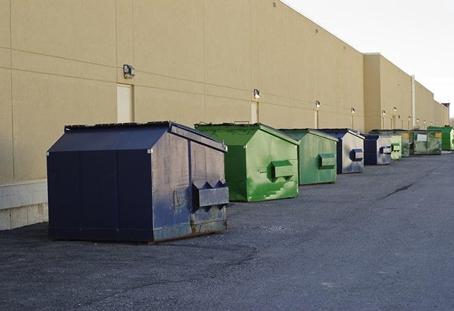 a row of blue construction dumpsters on a job site in Avoca